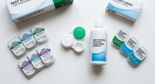 Several contact lens types beside a clean lens case and solution bottle